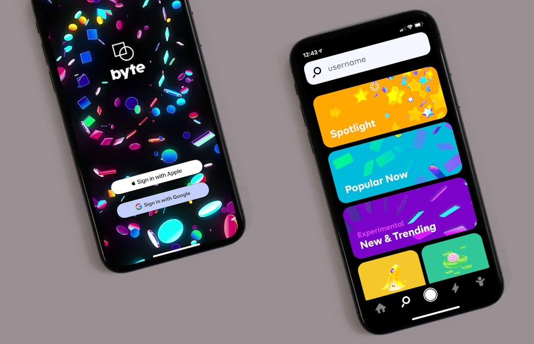 Two black smartphones on a grey surface showing mobile app login and content discovery screens