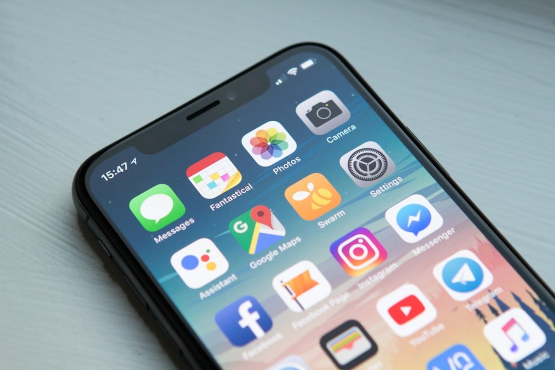 Space gray iPhone X displaying the home screen with app icons in a bright studio setting