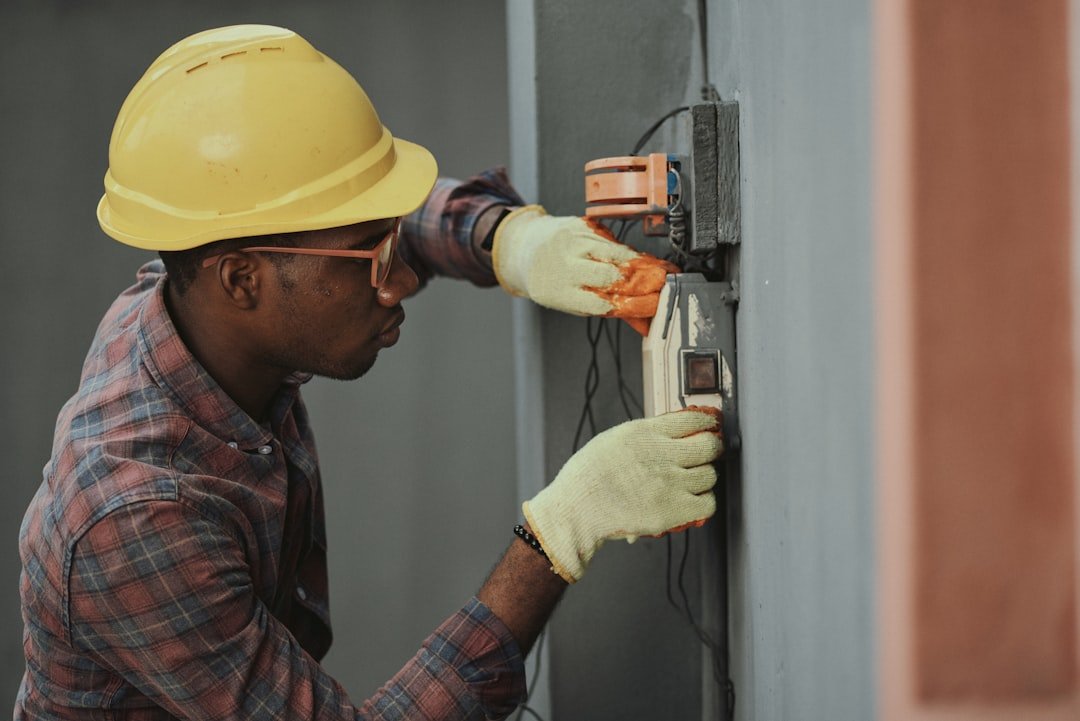 Confident field service worker in hardhat and safety goggles standing at an outdoor construction site